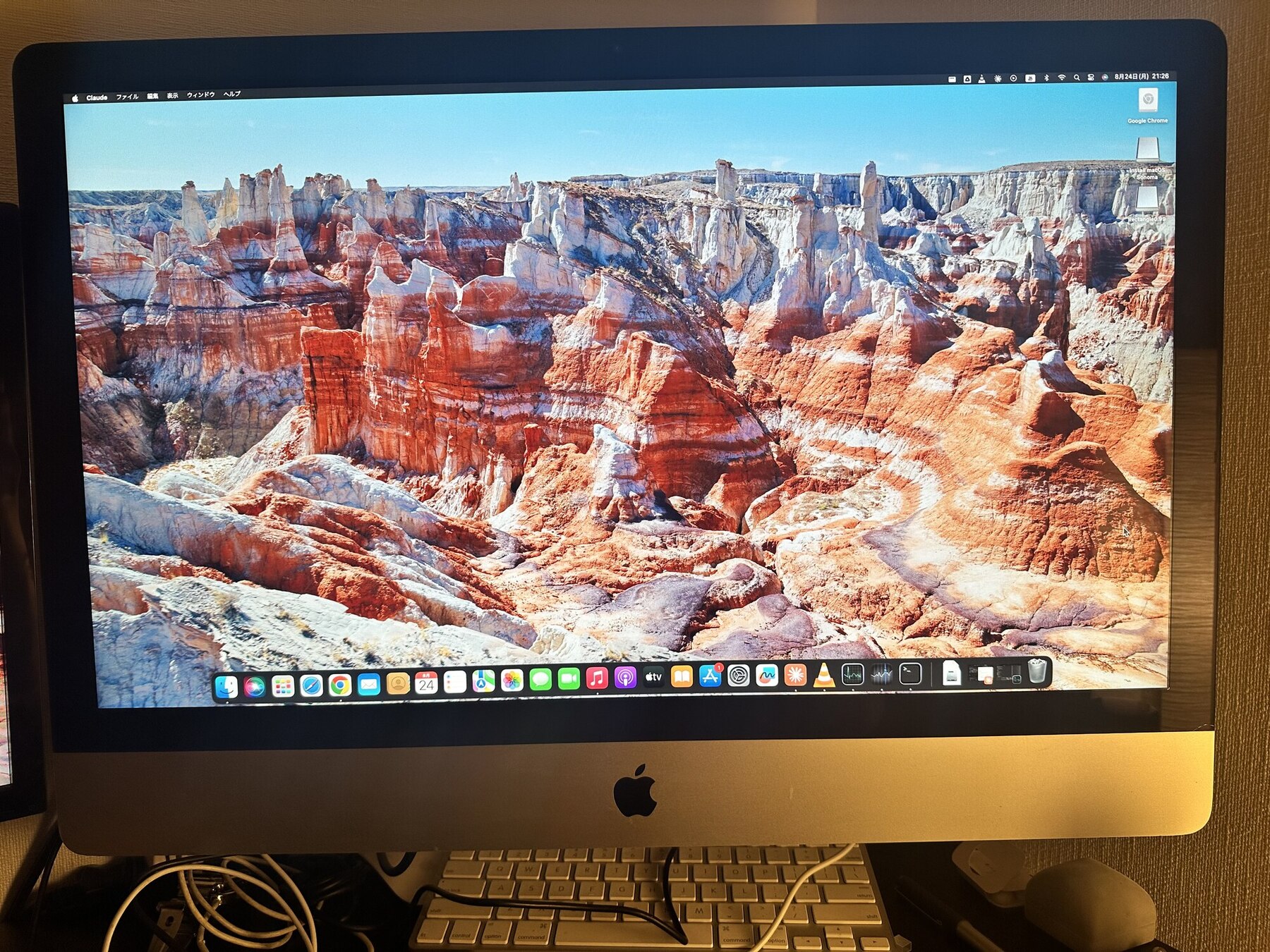 27インチiMacのデスクトップ画面。メニューバーにClaudeのメニューが表示されている